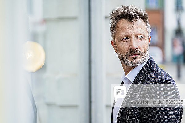 Porträt eines reifen Geschäftsmannes mit grauem Bart  der etwas beobachtet