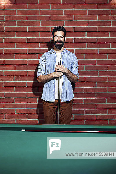Portrait of smiling man at billiard table