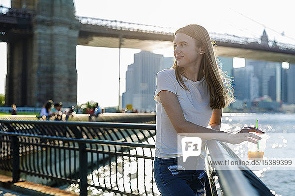 Young woman exploring New York City  looking at Brooklyn Bridge