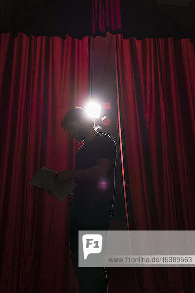 Schauspieler der auf der Bühne des Theaters steht und das Drehbuch studiert