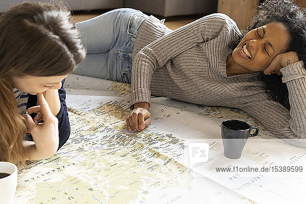 Friends putting pins on a map  planning their vacations