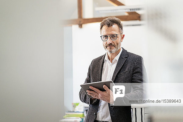 Portrait of businessman using tablet in office