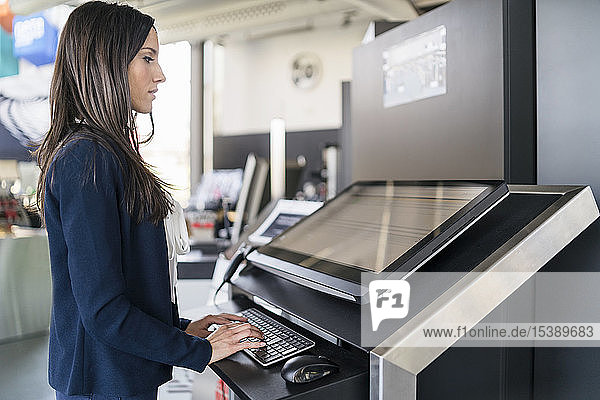 Businesswoman operating machine in a modern factory