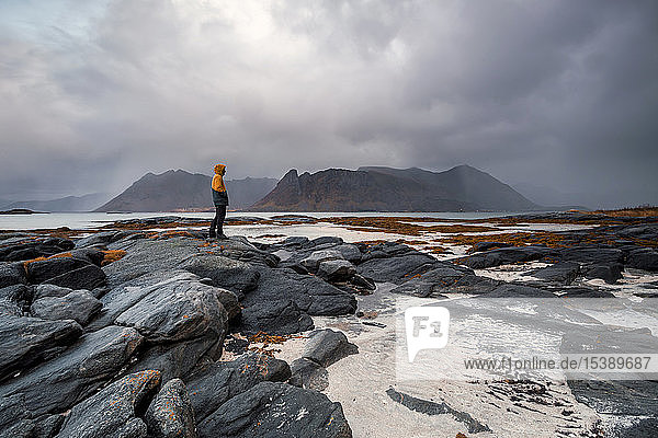 Norway  Lofoten Islands  Gimsoysand  man standing at rocky coast
