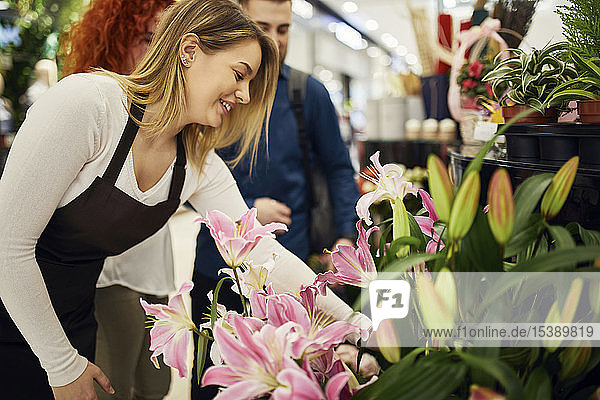 Verkäuferin berät Ehepaar im Blumenladen