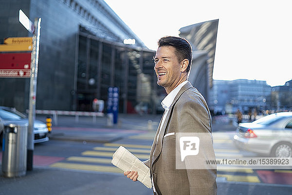 Happy businessman on the move in the city
