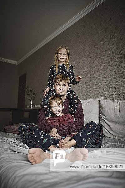 Familienportrait von Vater und zwei Kindern zu Hause
