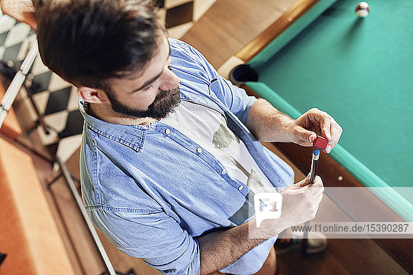 Man preparing his billiards cue