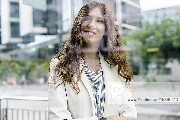 Junge Geschäftsfrau  die in der Stadt kommuniziert und glücklich lächelt