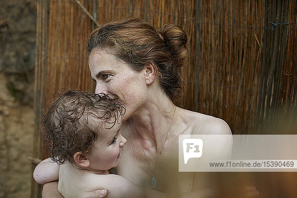 Mutter und kleine Tochter unter der Dusche im Freien