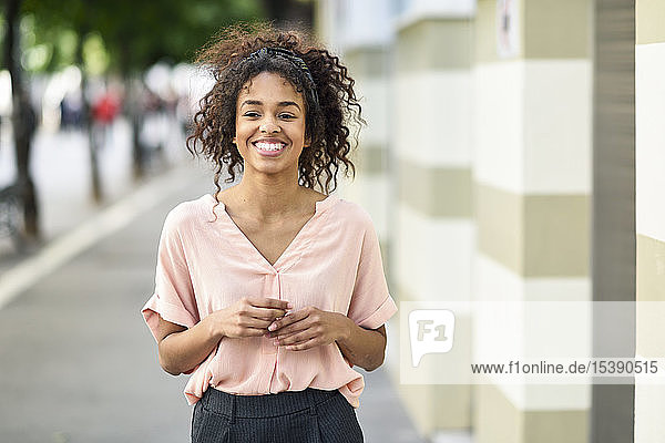 Portrait of smiling young woman in the city