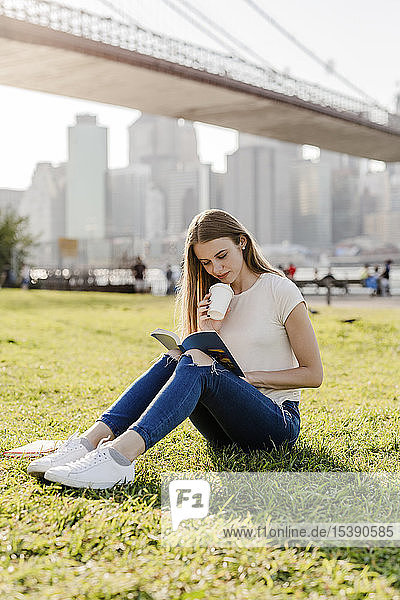 Junge Frau erkundet New York City  macht eine Pause  liest ein Buch