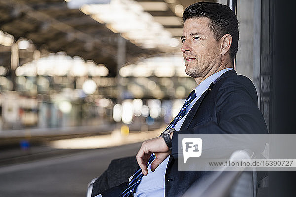Geschäftsmann wartet auf dem Bahnsteig