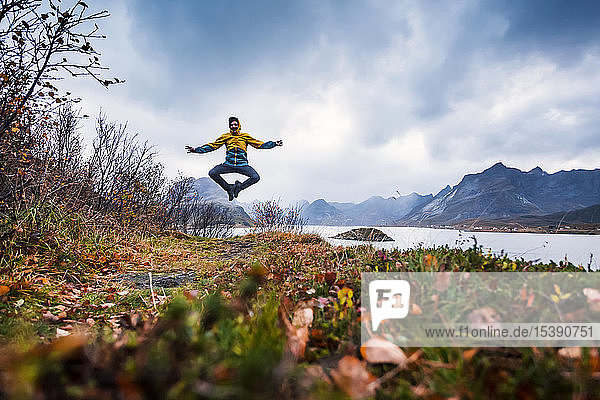 Norwegen Lofoten Mann springt an die Küste