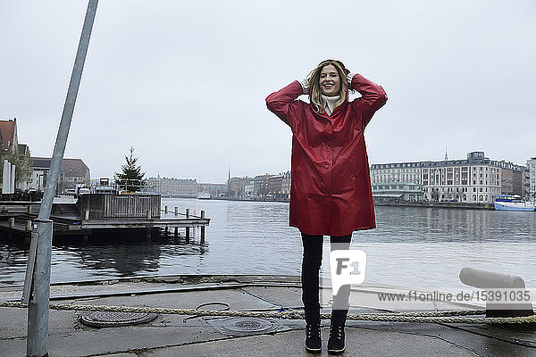 Dänemark  Kopenhagen  glückliche Frau an der Uferpromenade bei Regenwetter