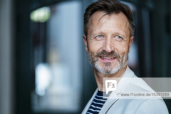 Porträt eines lächelnden reifen Mannes mit grauem Bart
