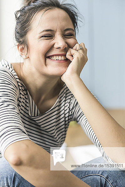 Portrait of happy woman sitting on the floor at home