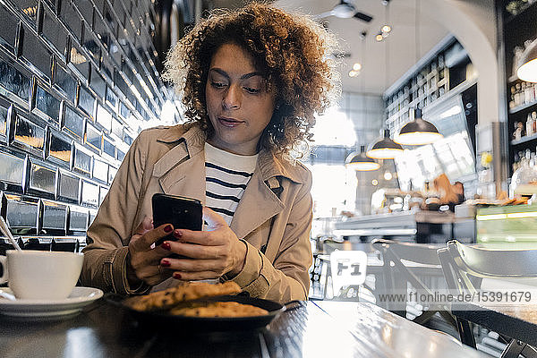 Woman using cell phone in a cafe