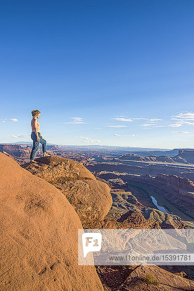 USA  Utah  Woman at a overlook over the canyonlands and the Colorado river from the Dead Horse State Park
