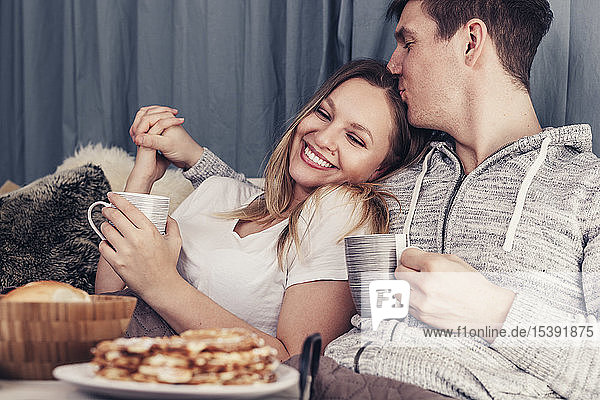 Affectionate young couple having breakfast in bed