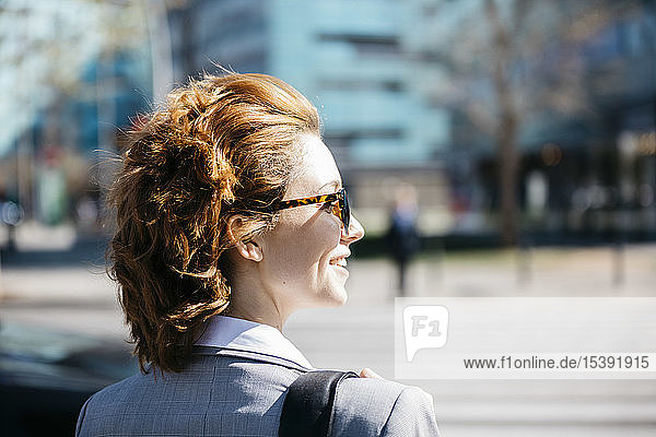 Rückansicht einer lächelnden Geschäftsfrau mit Sonnenbrille