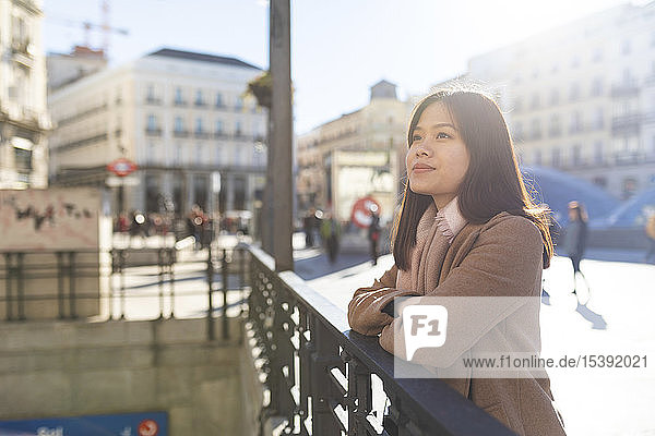 Spanien  Madrid  lächelnde junge Frau an der Puerta del Sol schaut sich um