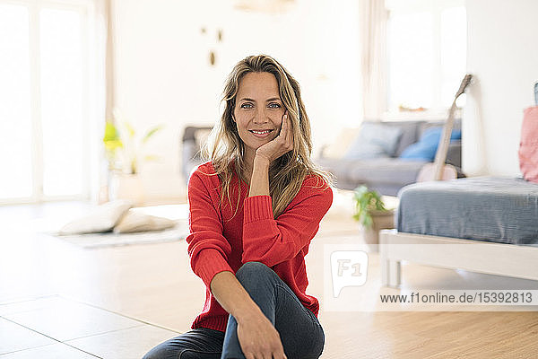 Portrait of smiling woman sitting on the floor at home