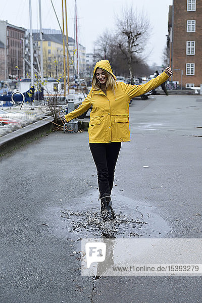 Dänemark  Kopenhagen  glückliche Frau springt im Stadthafen in Pfützen
