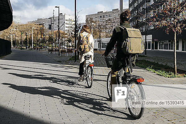 Ein Paar fährt E-Bikes in der Stadt  Rückansicht