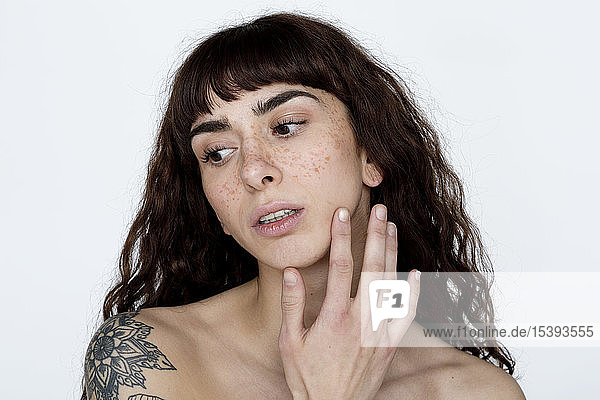 Portrait of tattooed young woman with freckles
