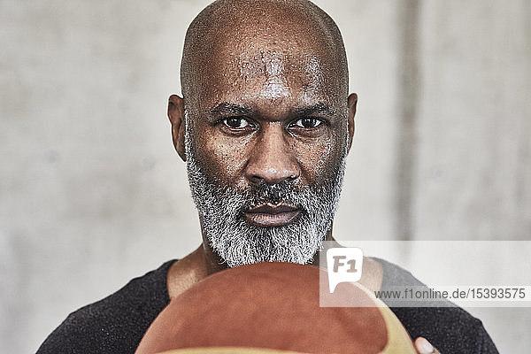 Porträt eines ernsthaften reifen Mannes  der Basketball hält