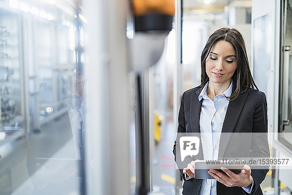Businesswoman using tablet in a modern factory