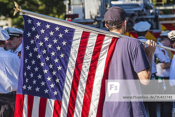 USA New England Massachusetts Cape Ann Rockport Rockport Fourth of July Parade young man with US flag NR.