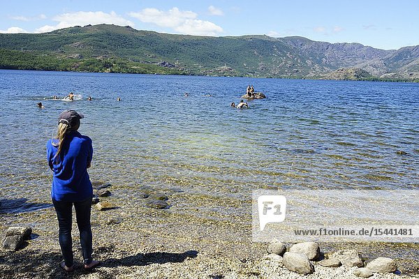A girl watches as the friends bathe and play in the water of the lakes of Sanabria