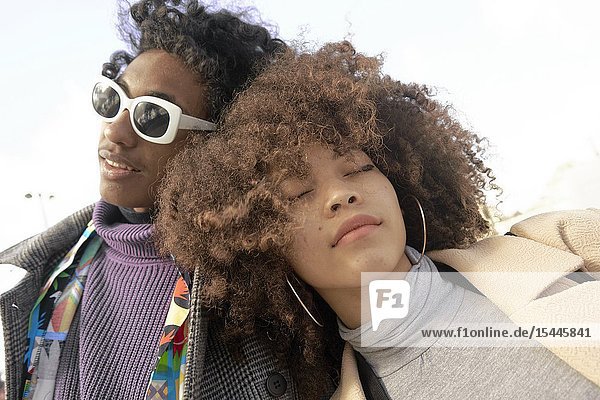 Young fashionable mixed-race couple resting on each other in Paris France