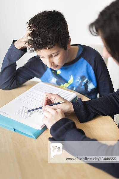 Private tutoring at home-10-11 years boy having a maths lesson at home.