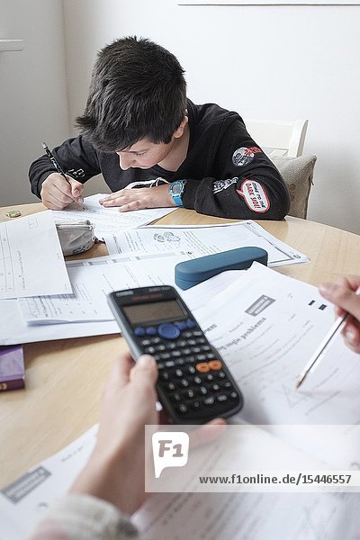 Children study together- revising exams papers at home.