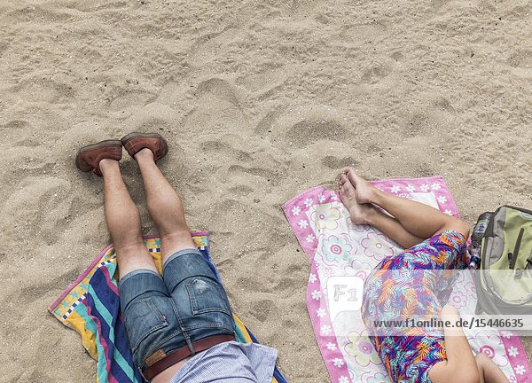 Man and woman sleeping on beach in Las Palmas Gran Canaria Canary Islands Spain.