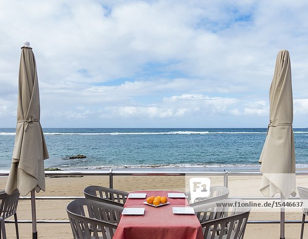 Las Palmas Gran Canaria Canary Islands Spain. Empty restaurant table overlooking Las Canteras beach.