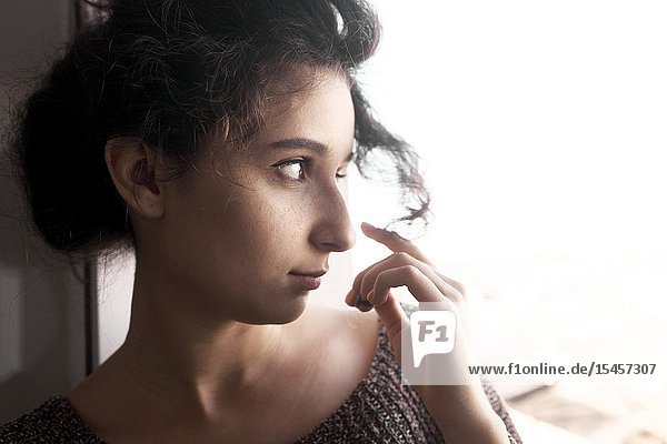Young thoughtful woman playing with her hairs