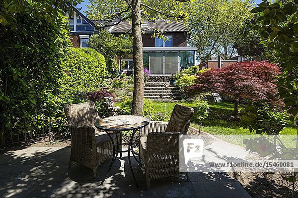 Oberhausen Sterkrade residential house with winter garden single-family home row house garden side flower garden rock garden rockery outside staircase perron natural stone stairs overshadowed sitting area with table and two chairs D-Oberhausen D-Oberhausen-Sterkrade Lower Rhine Ruhr area North Rhine-Westphalia NRW *** Local Caption ***.