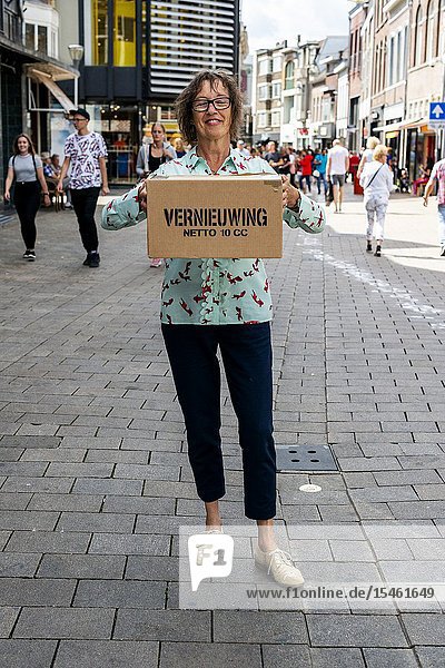 Tilburg Netherlands. During the CapeTown karton boxes artwork project all kinds of wishes printed on boxes were distributed to people passing by. Sjon's Wife distributing one wish box to the Public in the streets of down town.