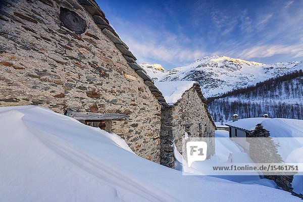 Stone huts covered with snow Alpe Groppera Madesimo Valchiavenna Valtellina Sondrio province Lombardy Italy.