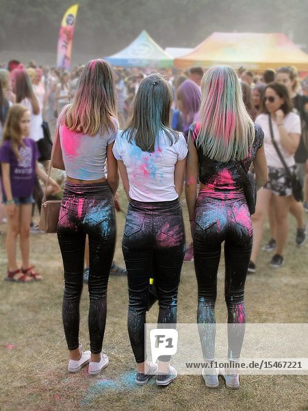 Tree girls with traces of hands on buttocks at Color festival Krakow Poland.