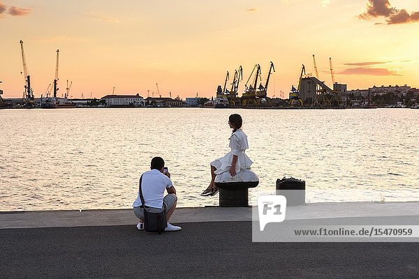 Young couple taking photos Port of Burgas Bulgaria.