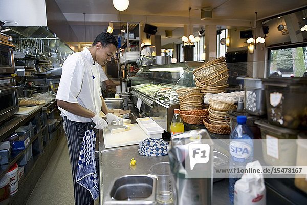 Rotterdam Netherlands. Chef and culinary cook preparing a lunch inside the professional restaurant kitchen of Wester Paviljoen on Nieuwe Binnenweg.