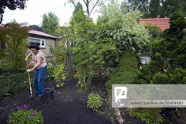 Tilburg Netherlands. Senior adult woman working in the garden at her rural garden shed inside the grounds of 'Tot Nut en Genoegen'.