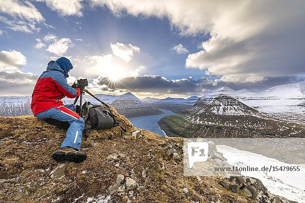 Photographer take a picture from a mountain near the villages of Funningur and Gjogv (Eysturoy island Faroe Islands Denmark) (MR).
