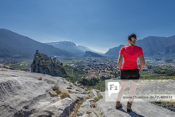 Arco Trento province Trentino Italy Europe. A Woman admires the panorama of the mountain Colodri the view extends over the city of Arco to the Lake Garda.
