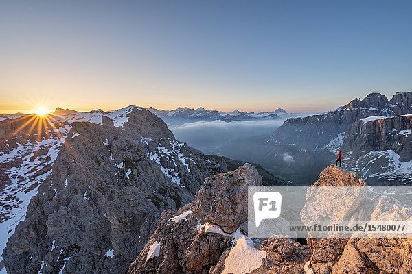 Gran Cir Gardena Pass Dolomites Bolzano district South Tyrol Italy Europe. A mountaineer admires the sunrise at the summit of the Gran Cir (MR).